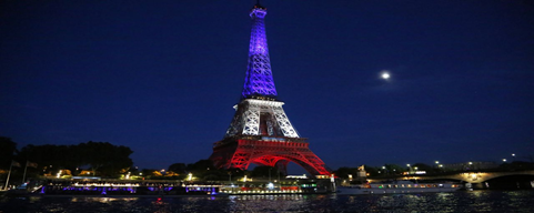 Widok na Wieżę Eiffla podświetloną w kolorach francuskiej flagi.