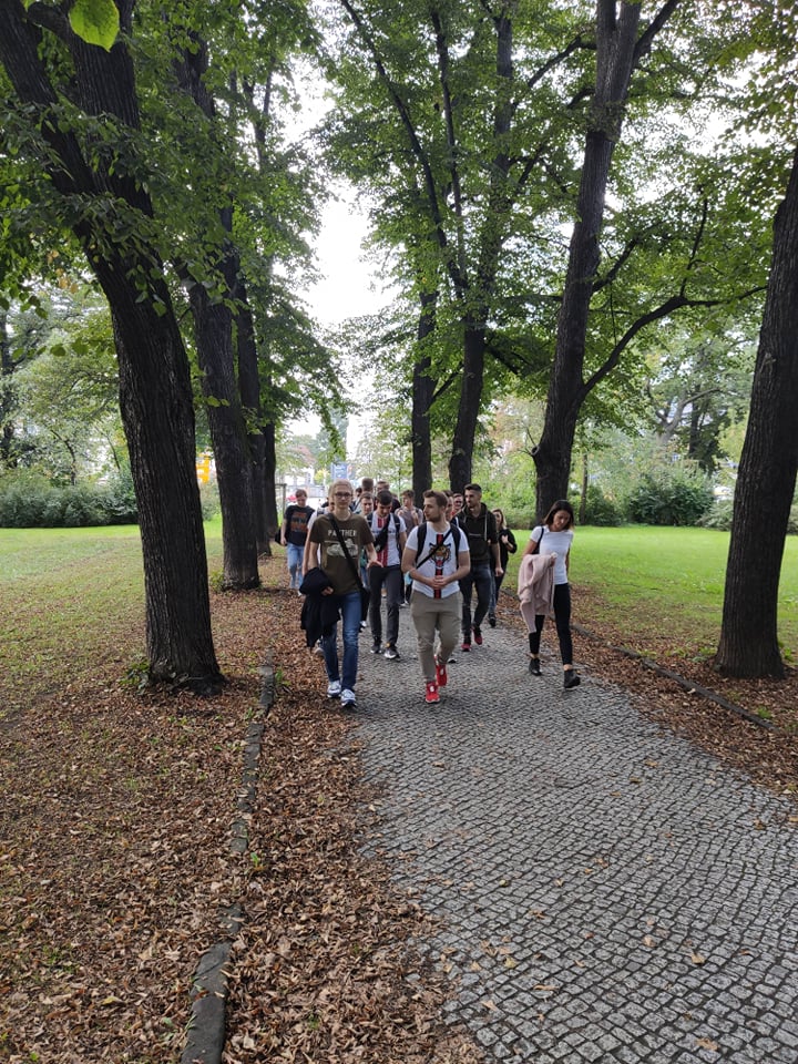 Uczniowie idą przez park.