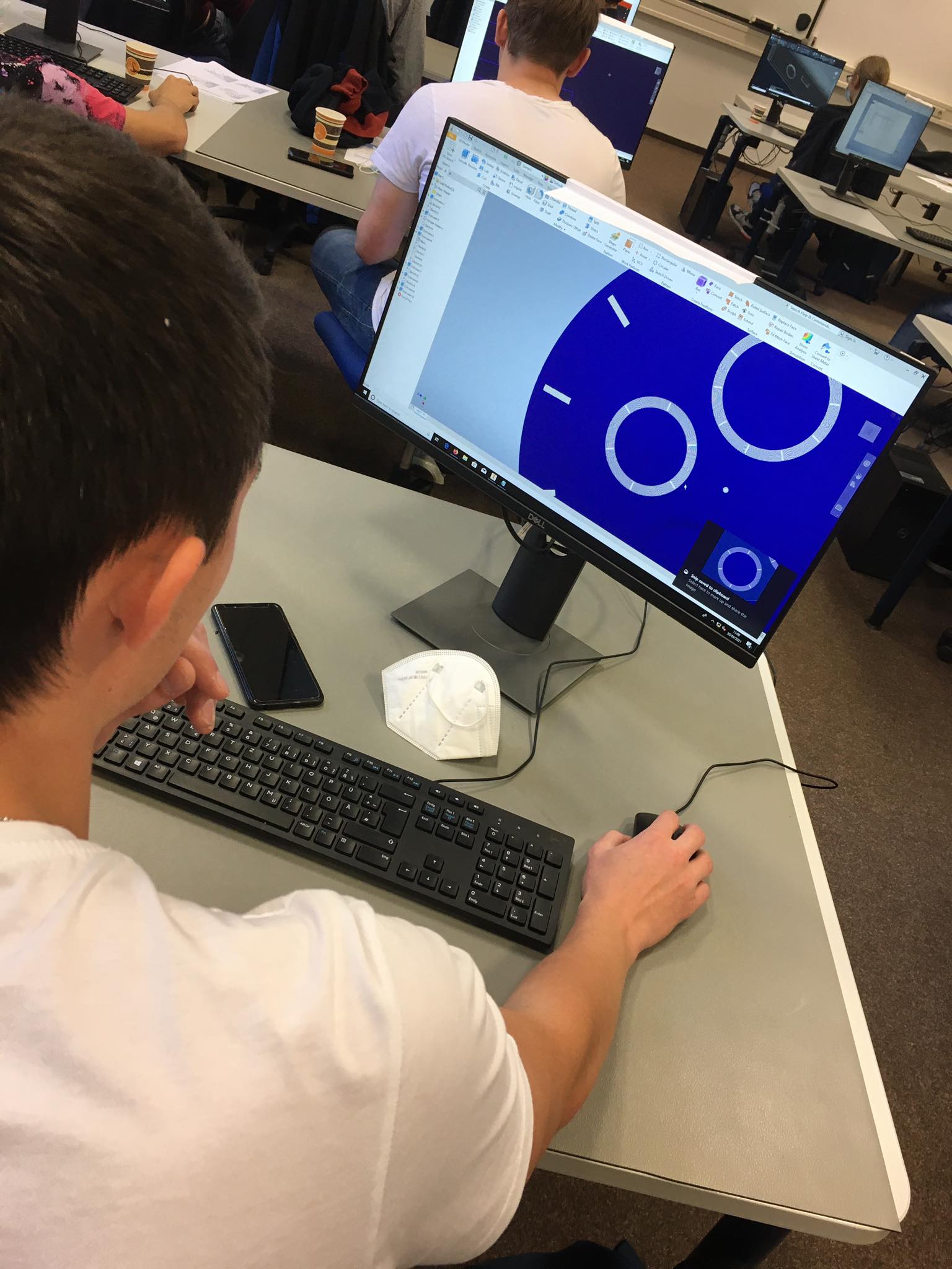 Uczeń rysuje model 3D fragmentu zegarka.
