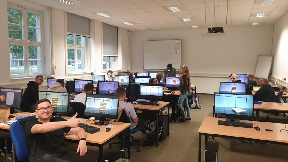 Uczniowie siedzą przy komputerach w centrum szkoleniowym.