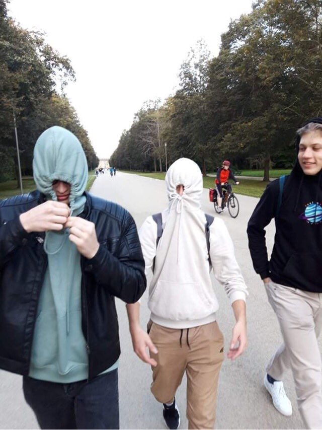 Uczniowie w parku w Dreźnie z zasłoniętymi twarzami.
