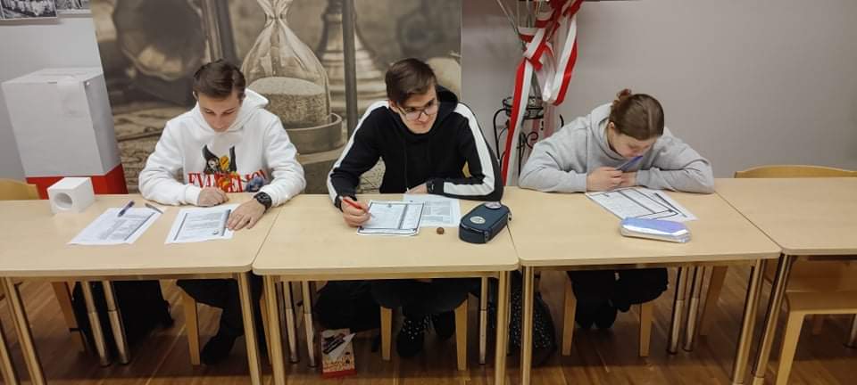 Troje uczniów przy biurku.