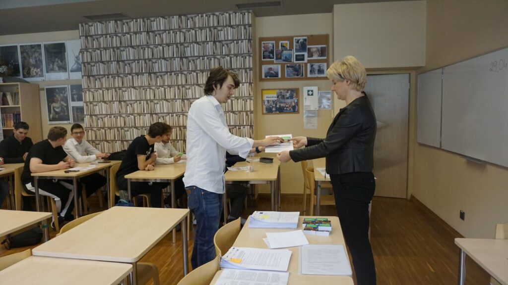 Uczeń odbiera z rąk Pani Dyrektor dyplom oraz słownik języka niemieckiego.