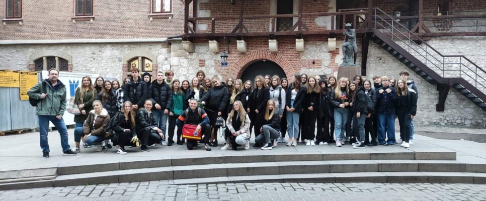 Zdjęcie grupowe uczestników wycieczki obok ulicy Floriańskiej w Krakowie.