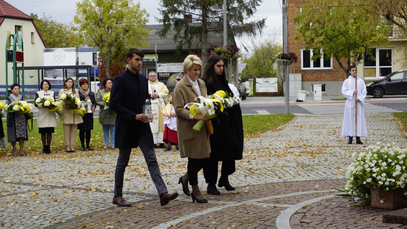 Dyrektor ZSP wraz z uczniami składa kwiaty pod pomnikiem