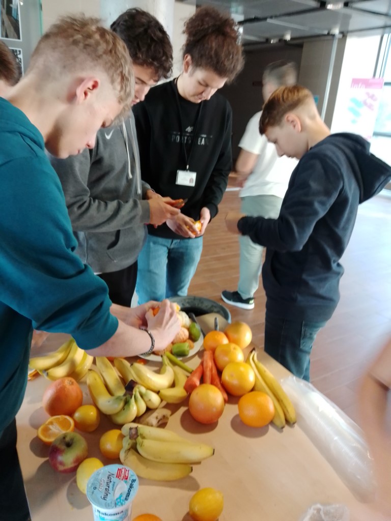 uczniowie obierają owoce