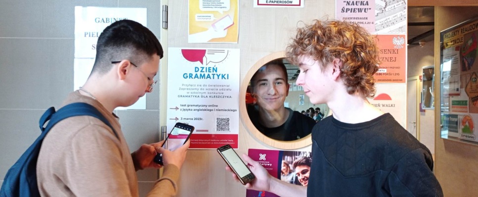 Uczniowie skanujący kod QR zawierający quiz gramatyczny z języka niemieckiego i angielskiego.