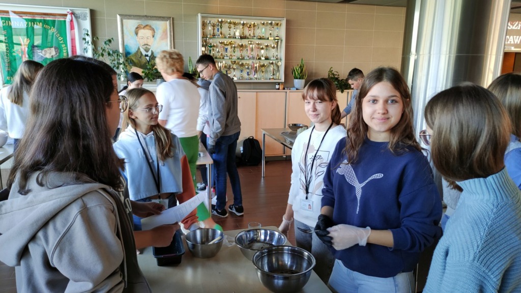 Uczniowie klasy I a oraz nauczycielki wychowania fizycznego w trakcie pieczenia chleba w ramach tygodnia zdrowia