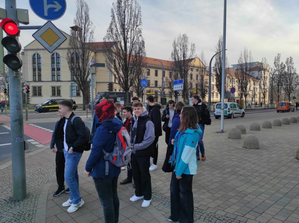Uczniowie stoją przy przejściu dla pieszych.