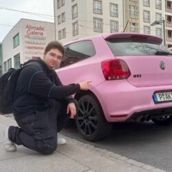 Uczeń prezentuje różowy samochód.