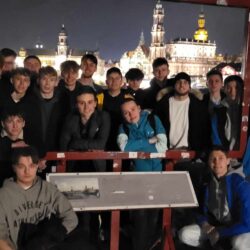 Grupa uczniów stoi na tle panoramy Drezna.