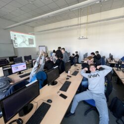 Uczniowie siedzą przy komputerach w Centrum szkoleniowym.