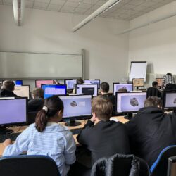 Grupa uczniów wykonuje model 3D na komputerze w Centrum Szkoleniowym.