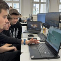 Grupa uczniów wykonuje modele na komputerach.