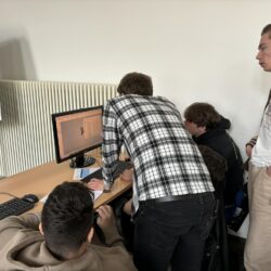 Grupa uczniów wykonuje model 3D na komputerze w Centrum Szkoleniowym.