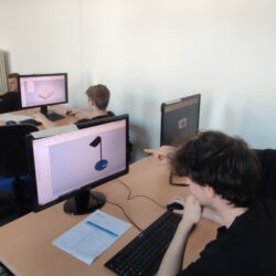 Grupa uczniów tworzy modele 3D na komputerach.