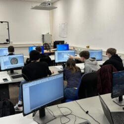 Grupa uczniów wykonuje modele na komputerach.