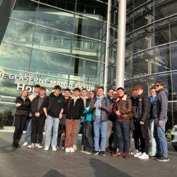 Grupa uczniów stoi przed Szklaną Manufakturą Volkswagena