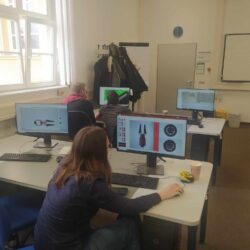 Grupa uczniów wykonuje modele na komputerach w Centrum Szkoleniowym.