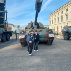 Grupa uczniów stoi przed czołgiem w Muzeum Wojckowo-Historycznym