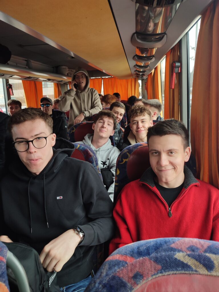 Uczniowie siedzą w autokarze jadącym do Drezna.
