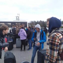 Uczniowie stoją z tormabami czekając na wyjazd do Drezna.