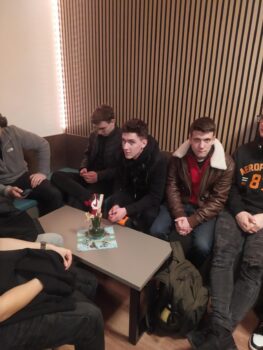 Uczniowie siedzą w poczekalni w hotelu w Dreżnie czekając na zakwaterowanie.